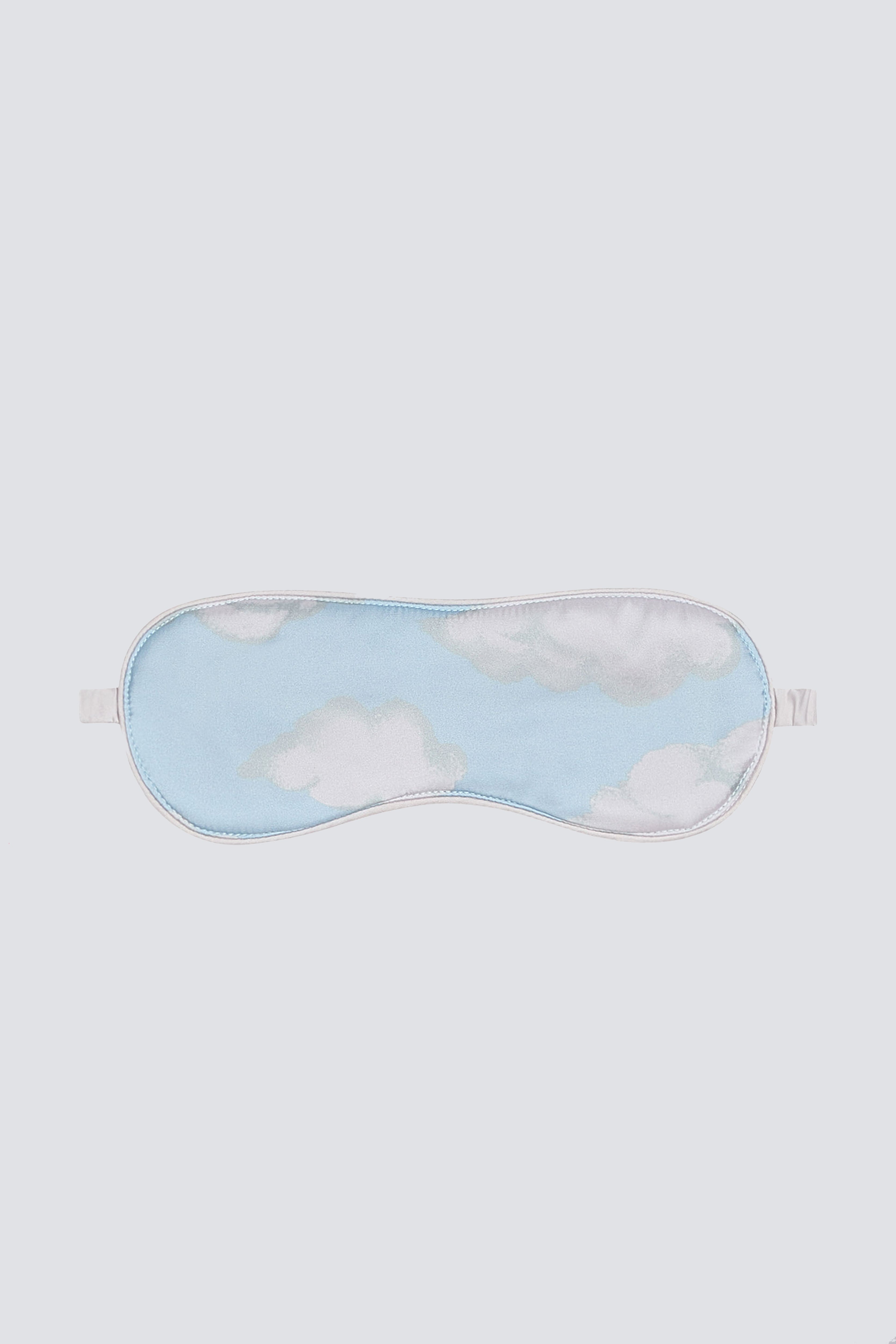 Sleep mask with cloud pattern on a light gray background