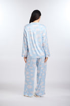 Person wearing a light blue pajama set with cloud pattern on a white background