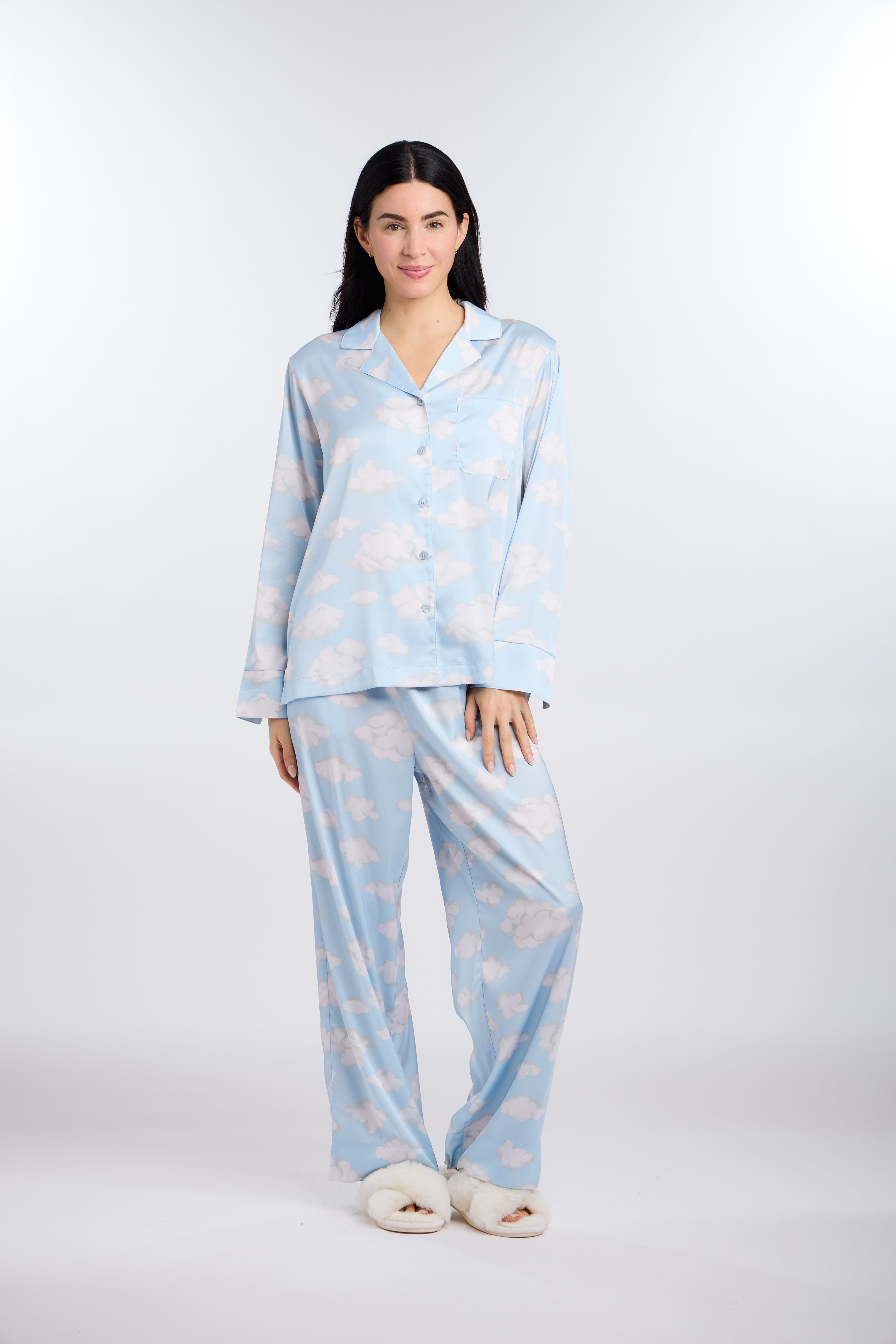 Woman wearing a light blue pajama set with cloud pattern on a white background
